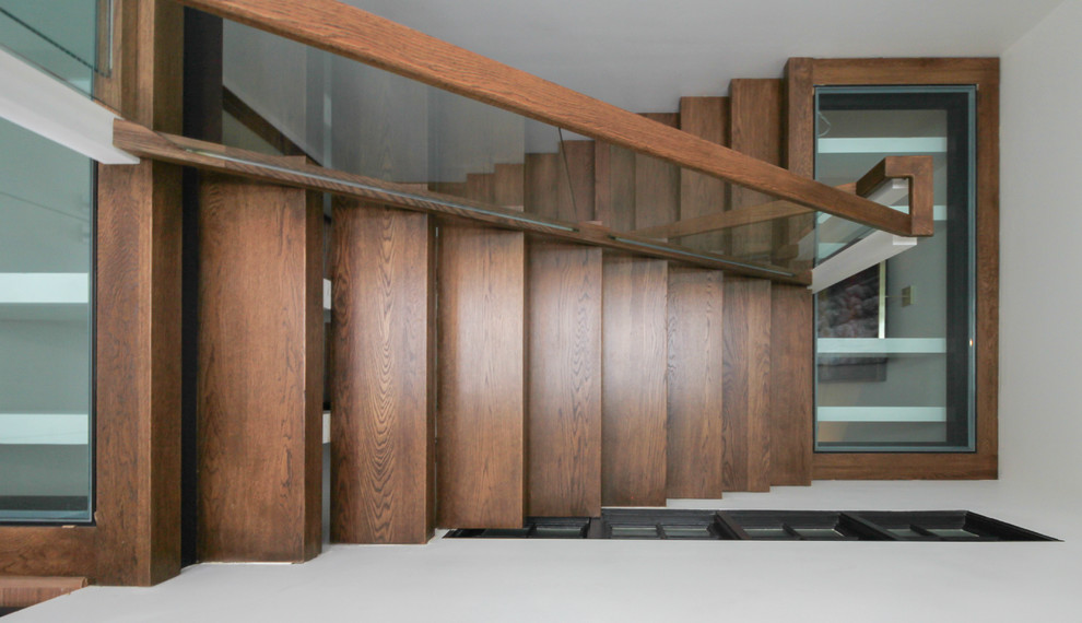 Ejemplo de escalera suspendida actual extra grande sin contrahuella con escalones de vidrio y barandilla de vidrio