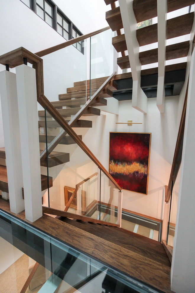 Foto de escalera suspendida actual extra grande sin contrahuella con escalones de vidrio y barandilla de vidrio