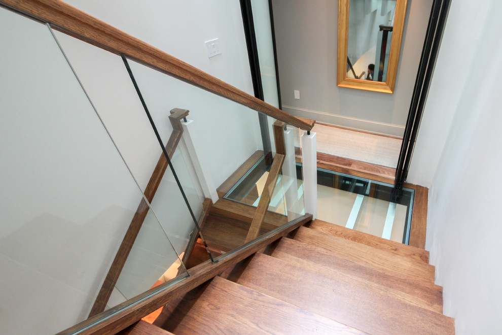 Modern inredning av en mycket stor flytande trappa i glas, med öppna sättsteg och räcke i glas