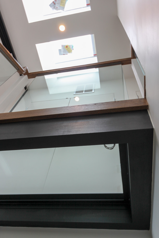 Huge trendy glass floating open and glass railing staircase photo in DC Metro