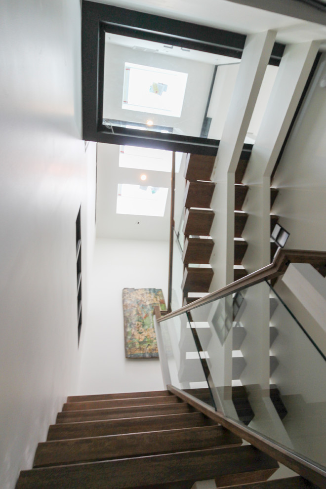 Diseño de escalera suspendida actual extra grande sin contrahuella con escalones de vidrio y barandilla de vidrio