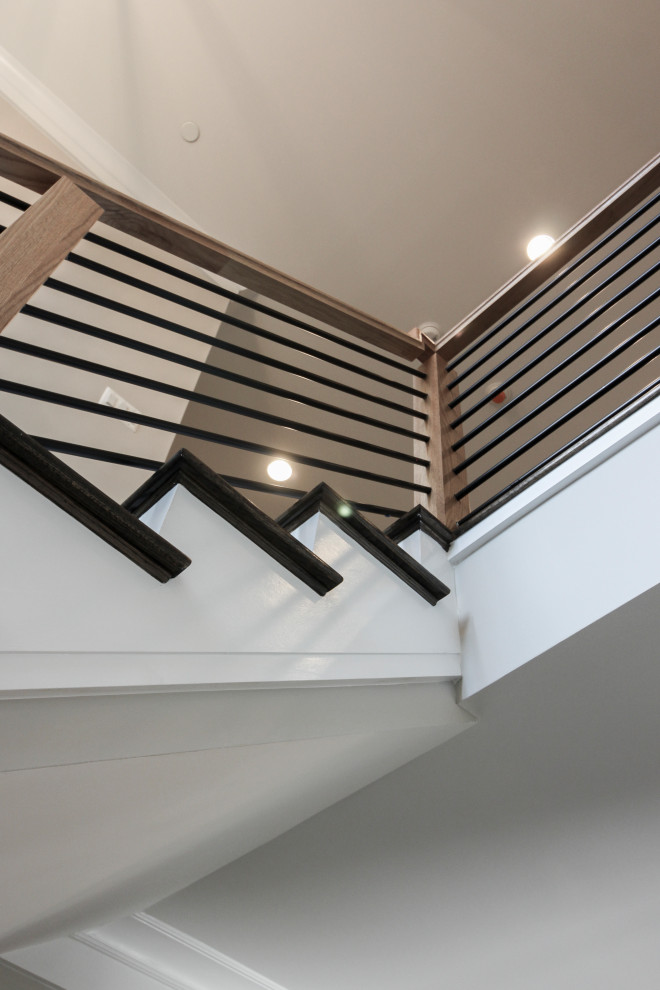 This is an example of a medium sized eclectic wood u-shaped mixed railing staircase in DC Metro with wood risers.