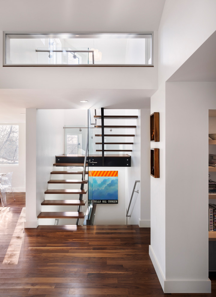 Пример оригинального дизайна: п-образная лестница в современном стиле с деревянными ступенями и стеклянными перилами без подступенок