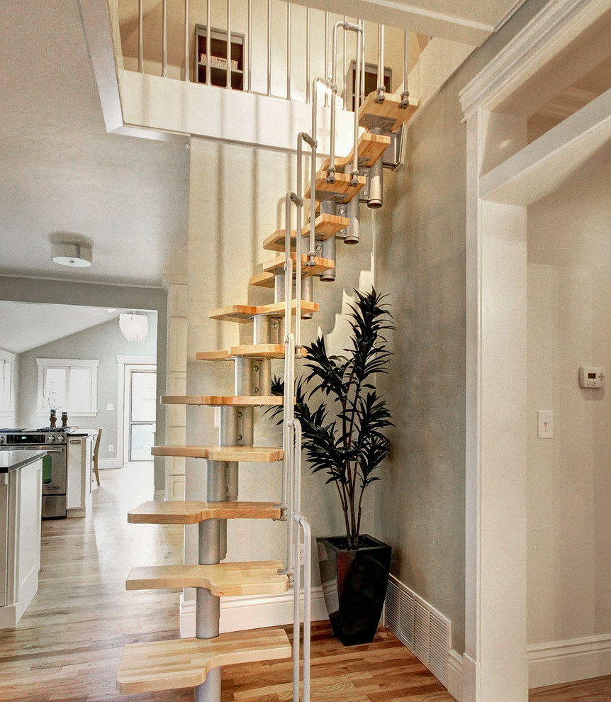 Idée de décoration pour un petit escalier sans contremarche hélicoïdal minimaliste avec des marches en bois et éclairage.