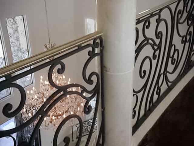 Foto de escalera curva romántica grande con escalones de madera, contrahuellas de madera y barandilla de metal