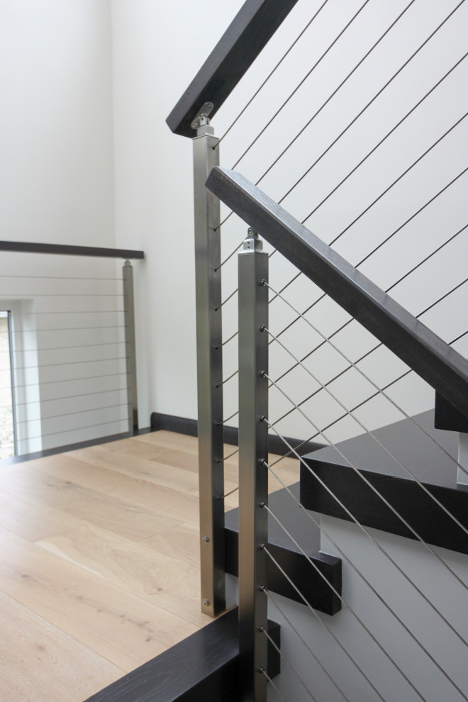 Свежая идея для дизайна: большая п-образная лестница в современном стиле с деревянными ступенями и перилами из смешанных материалов - отличное фото интерьера