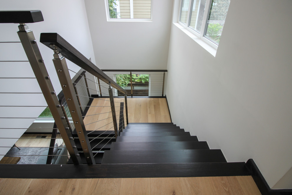 Foto de escalera en U contemporánea grande con escalones de madera y barandilla de varios materiales