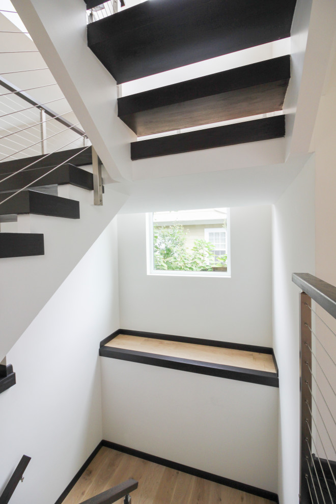 ワシントンD.C.にある高級な広いコンテンポラリースタイルのおしゃれな折り返し階段 (混合材の手すり) の写真
