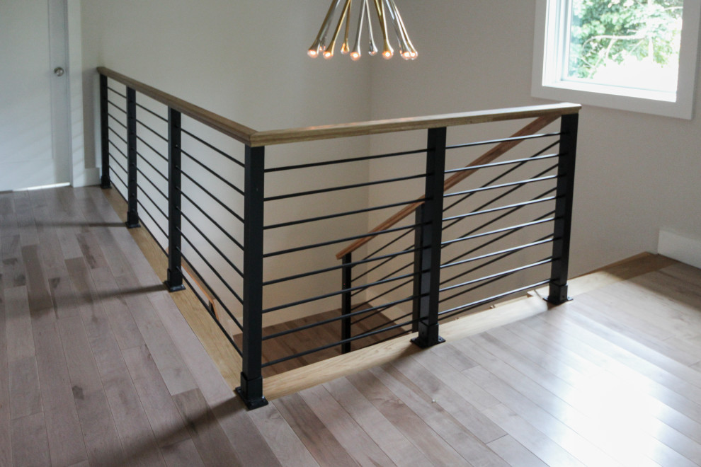 Diseño de escalera recta minimalista grande con escalones de madera, contrahuellas de madera y barandilla de varios materiales