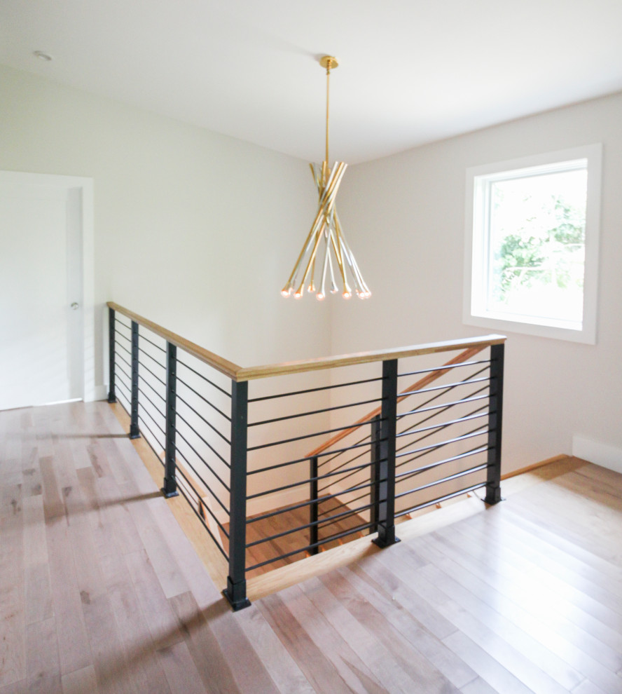 Ejemplo de escalera recta moderna grande con escalones de madera, contrahuellas de madera y barandilla de varios materiales