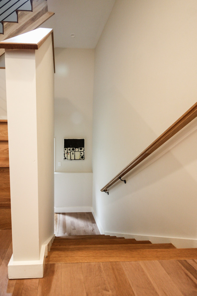 Diseño de escalera recta minimalista grande con escalones de madera, contrahuellas de madera y barandilla de varios materiales