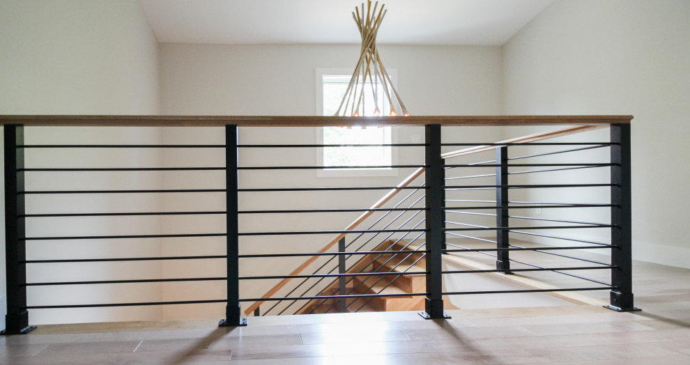 Diseño de escalera recta moderna grande con escalones de madera, contrahuellas de madera y barandilla de varios materiales