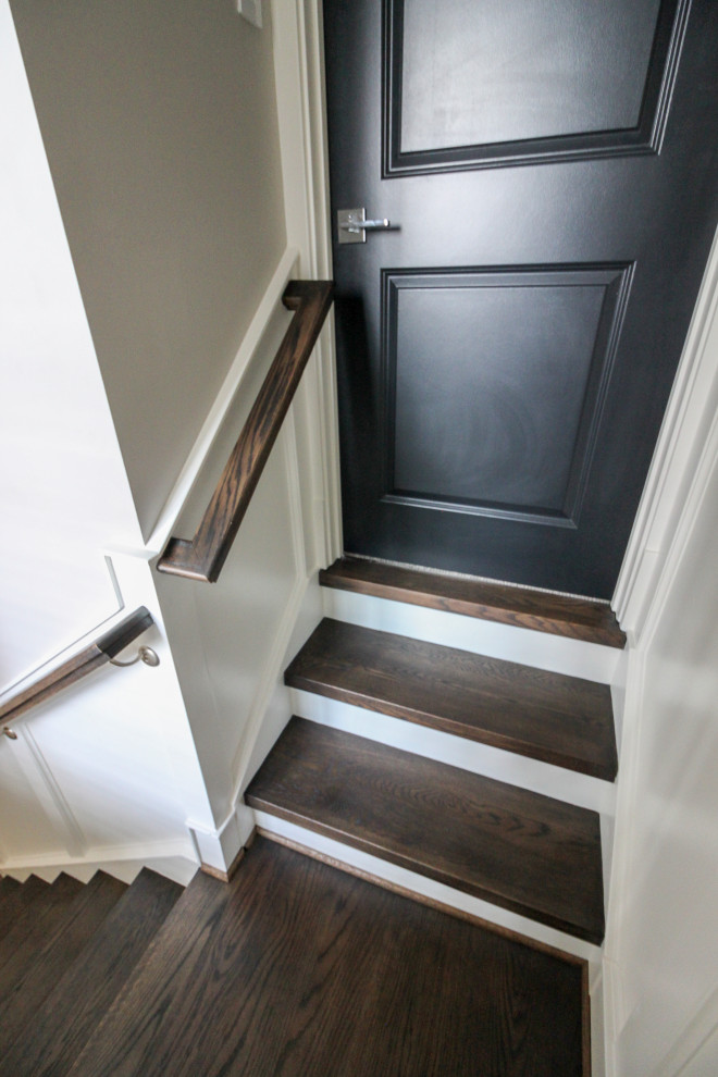 Cette photo montre un grand escalier tendance en U avec des marches en bois, des contremarches en bois et un garde-corps en matériaux mixtes.