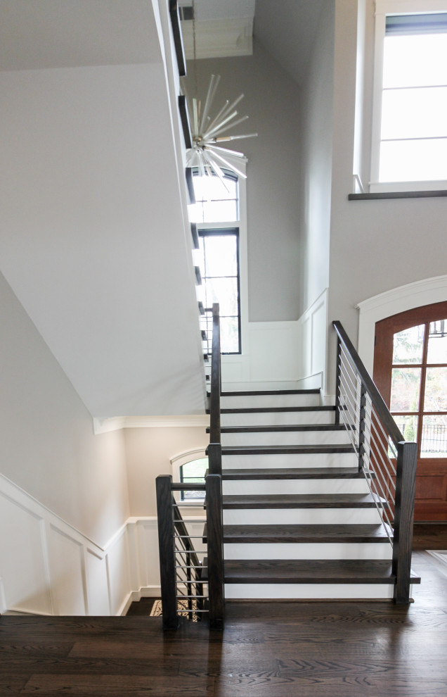 ワシントンD.C.にある高級な広いコンテンポラリースタイルのおしゃれな折り返し階段 (木の蹴込み板、混合材の手すり) の写真