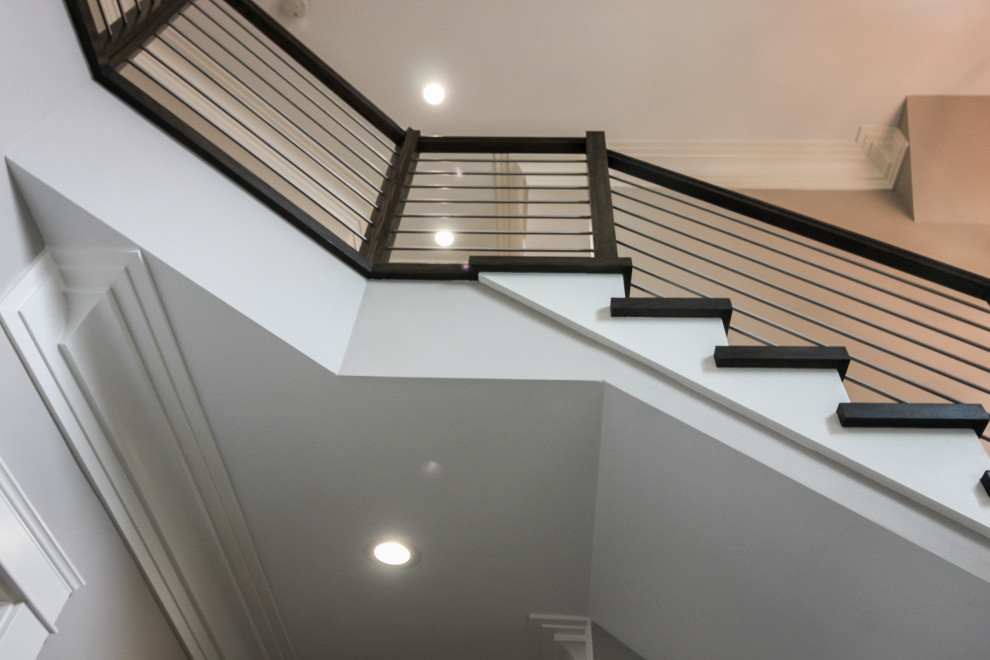 Modelo de escalera en U contemporánea grande con escalones de madera, contrahuellas de madera y barandilla de varios materiales