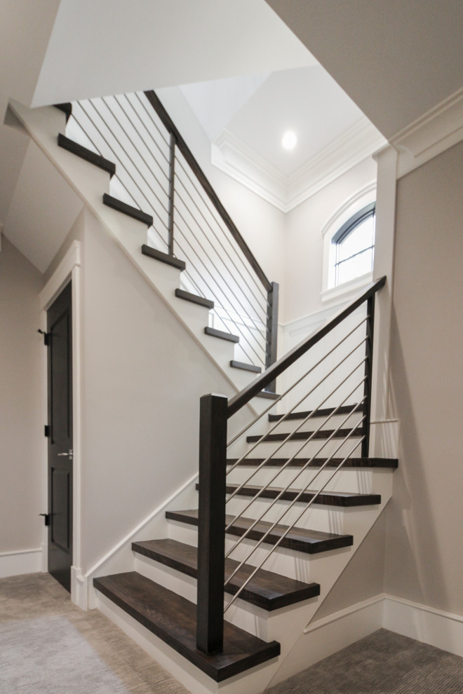 Cette image montre un grand escalier design en U avec des marches en bois, des contremarches en bois et un garde-corps en matériaux mixtes.