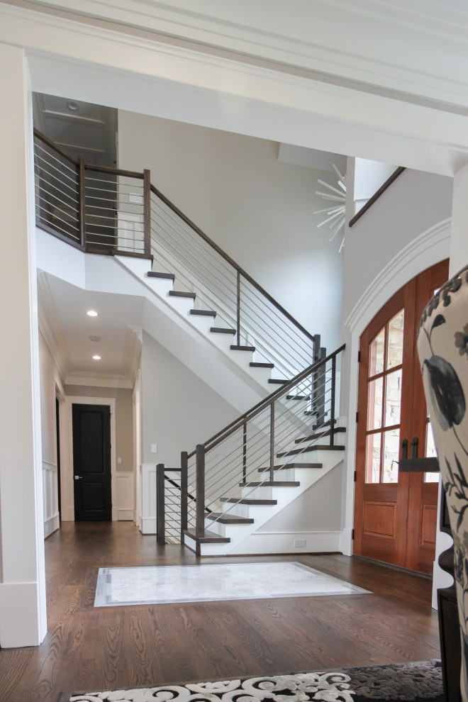 На фото: большая п-образная деревянная лестница в современном стиле с деревянными ступенями и перилами из смешанных материалов с
