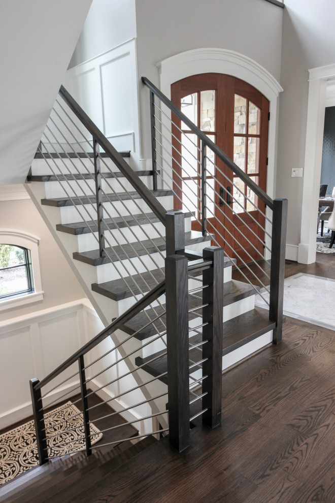 Inspiration pour un grand escalier design en U avec des marches en bois, des contremarches en bois et un garde-corps en matériaux mixtes.