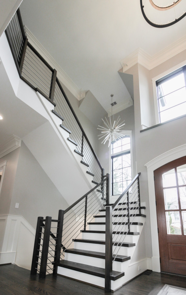 Cette image montre un grand escalier design en U avec des marches en bois, des contremarches en bois et un garde-corps en matériaux mixtes.