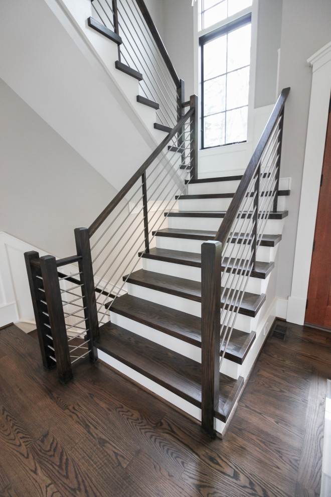 Пример оригинального дизайна: большая п-образная деревянная лестница в современном стиле с деревянными ступенями и перилами из смешанных материалов