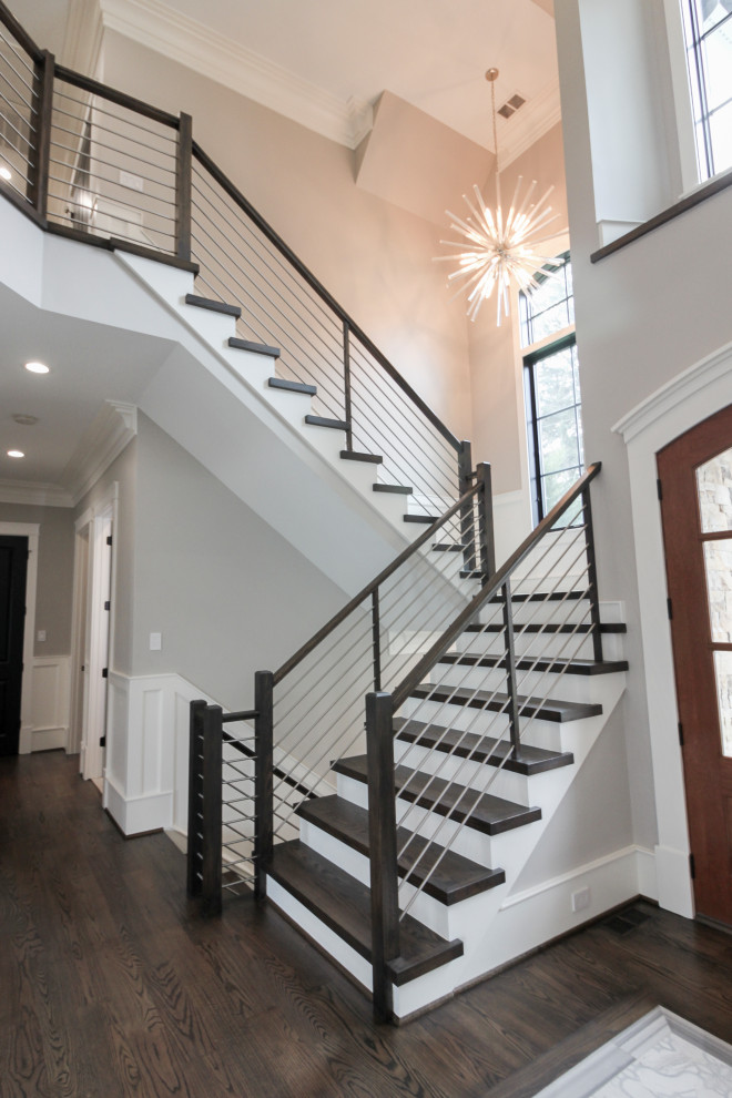 Exemple d'un grand escalier tendance en U avec des marches en bois, des contremarches en bois et un garde-corps en matériaux mixtes.