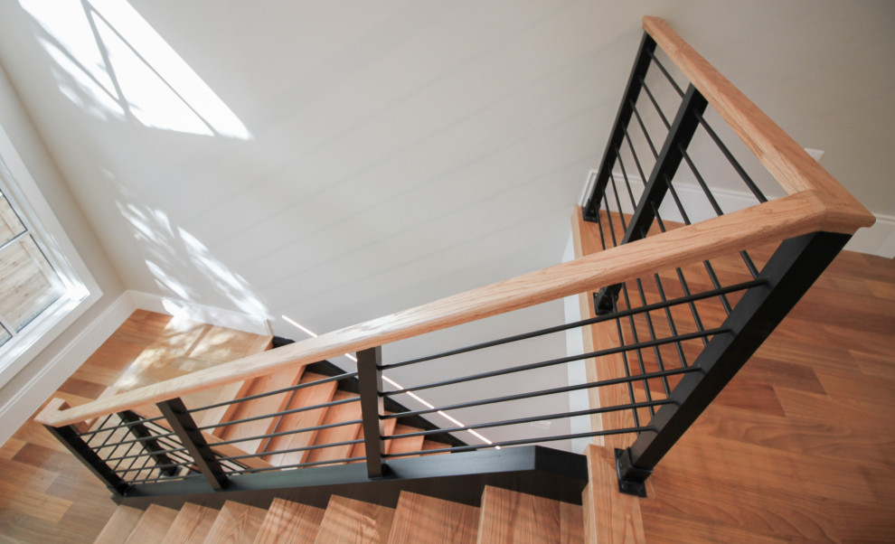 Inspiration pour un grand escalier design en U avec des marches en bois et un garde-corps en matériaux mixtes.
