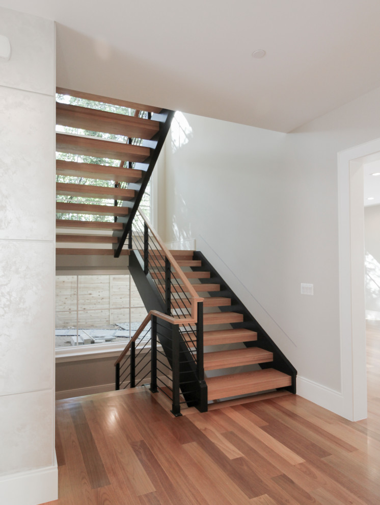 Diseño de escalera en U actual grande con escalones de madera y barandilla de varios materiales