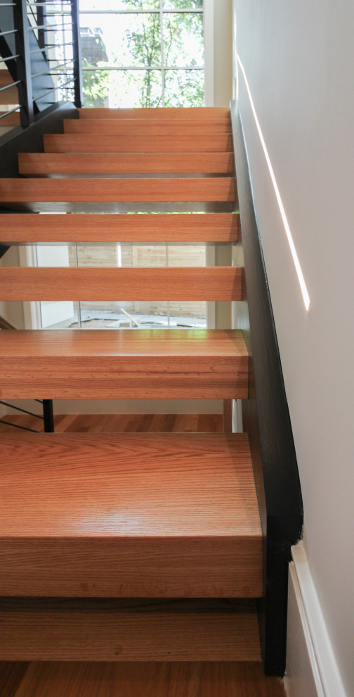 This is an example of a large contemporary wood u-shaped mixed railing staircase in DC Metro.