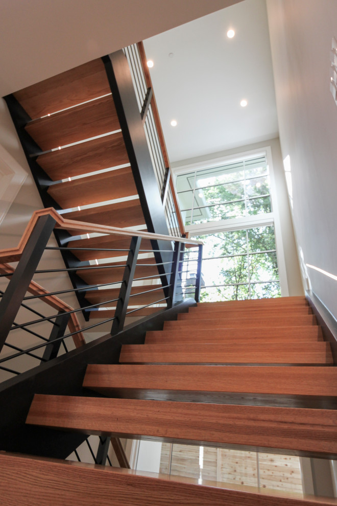 Idée de décoration pour un grand escalier design en U avec des marches en bois et un garde-corps en matériaux mixtes.