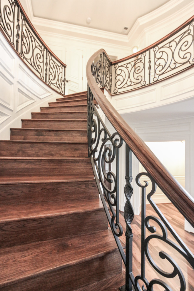 Photo of a large bohemian wood curved mixed railing staircase in DC Metro with wood risers.