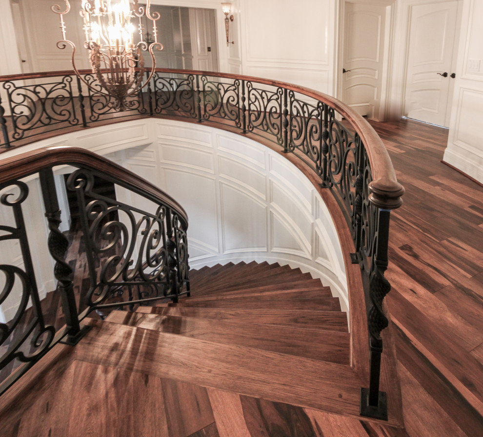 Foto de escalera curva ecléctica grande con escalones de madera, contrahuellas de madera y barandilla de varios materiales