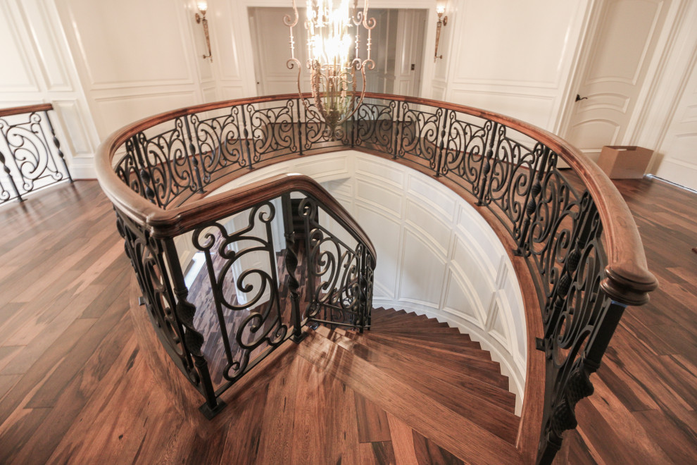 Inspiration for a large eclectic wooden curved mixed material railing staircase remodel in DC Metro with wooden risers