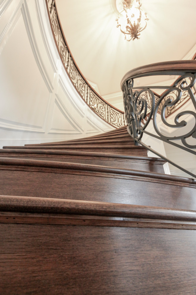 Idée de décoration pour un grand escalier courbe bohème avec des marches en bois, des contremarches en bois et un garde-corps en matériaux mixtes.