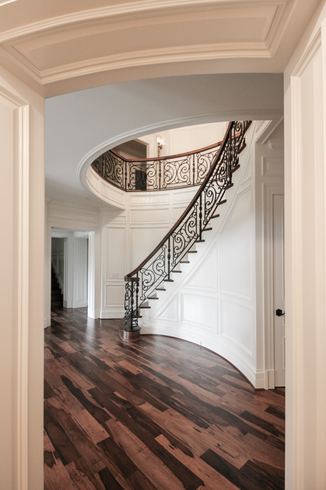 Inspiration for a large eclectic wooden curved mixed material railing staircase remodel in DC Metro with wooden risers