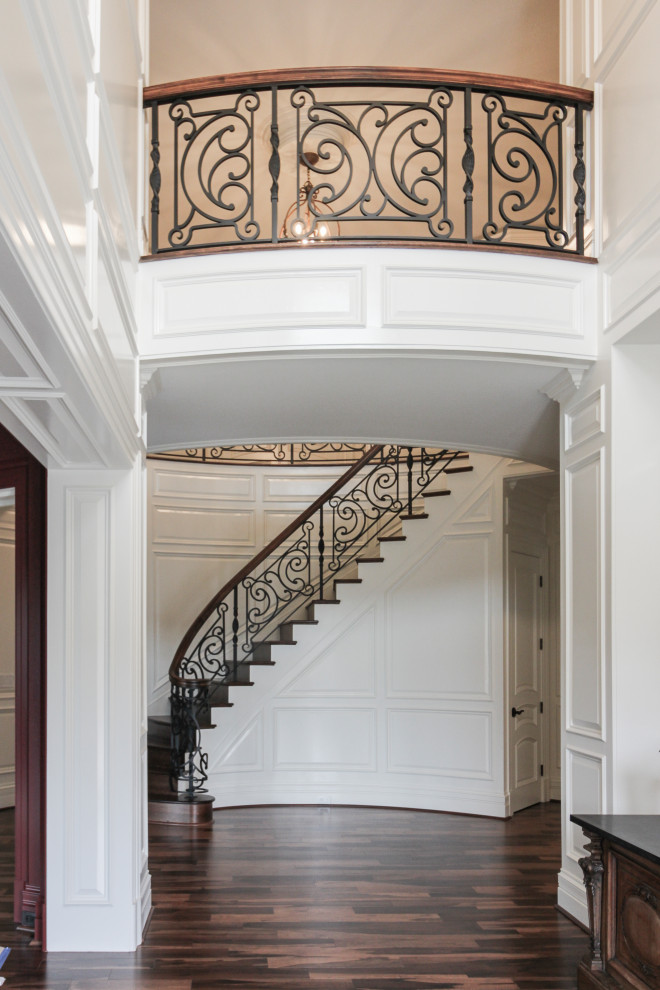 Idées déco pour un grand escalier courbe éclectique avec des marches en bois, des contremarches en bois et un garde-corps en matériaux mixtes.