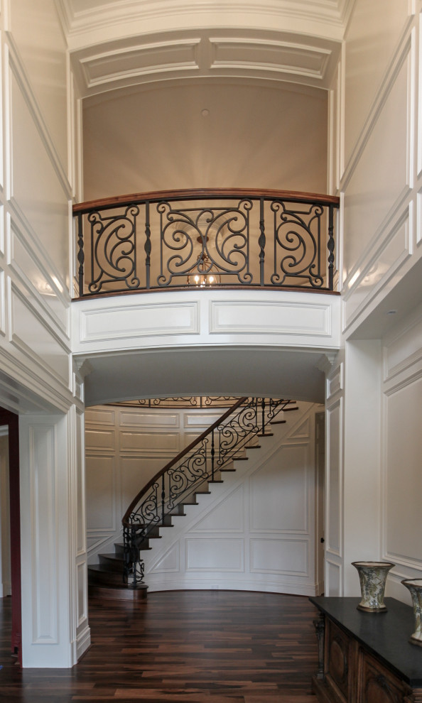 Imagen de escalera curva ecléctica grande con escalones de madera, contrahuellas de madera y barandilla de varios materiales