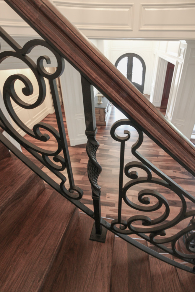 Ejemplo de escalera curva bohemia grande con escalones de madera, contrahuellas de madera y barandilla de varios materiales