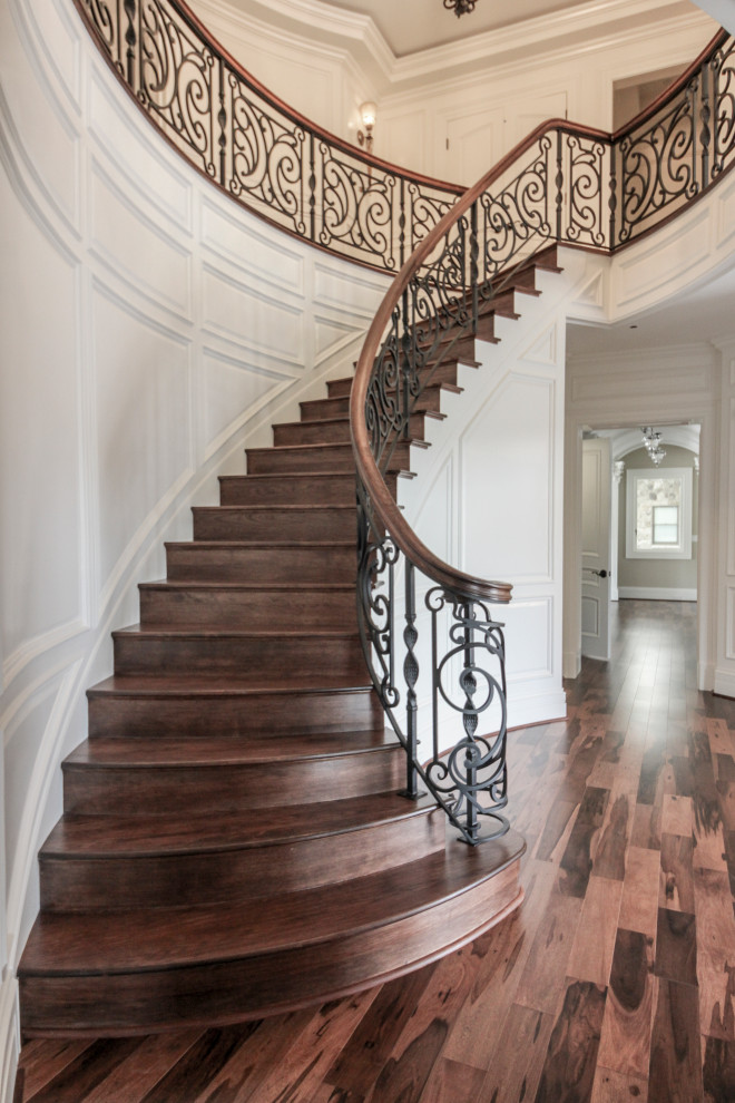 Large eclectic wooden curved mixed material railing staircase photo in DC Metro with wooden risers