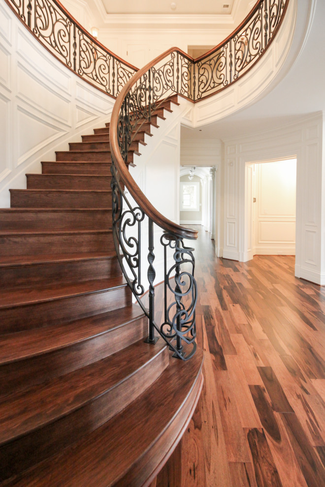 Foto de escalera curva bohemia grande con escalones de madera, contrahuellas de madera y barandilla de varios materiales