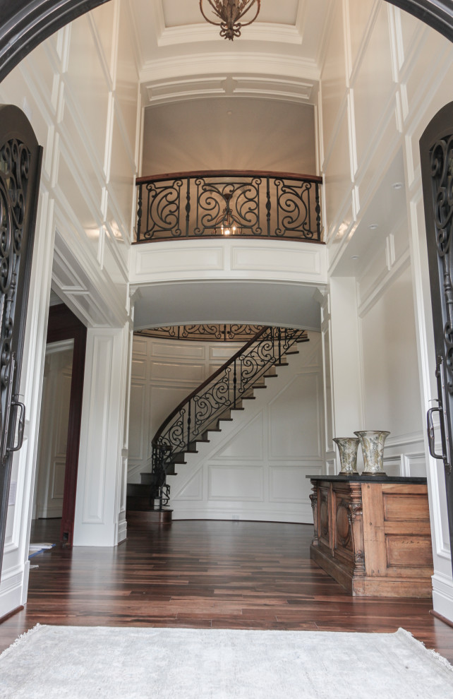 Свежая идея для дизайна: большая изогнутая деревянная лестница в стиле фьюжн с деревянными ступенями и перилами из смешанных материалов - отличное фото интерьера