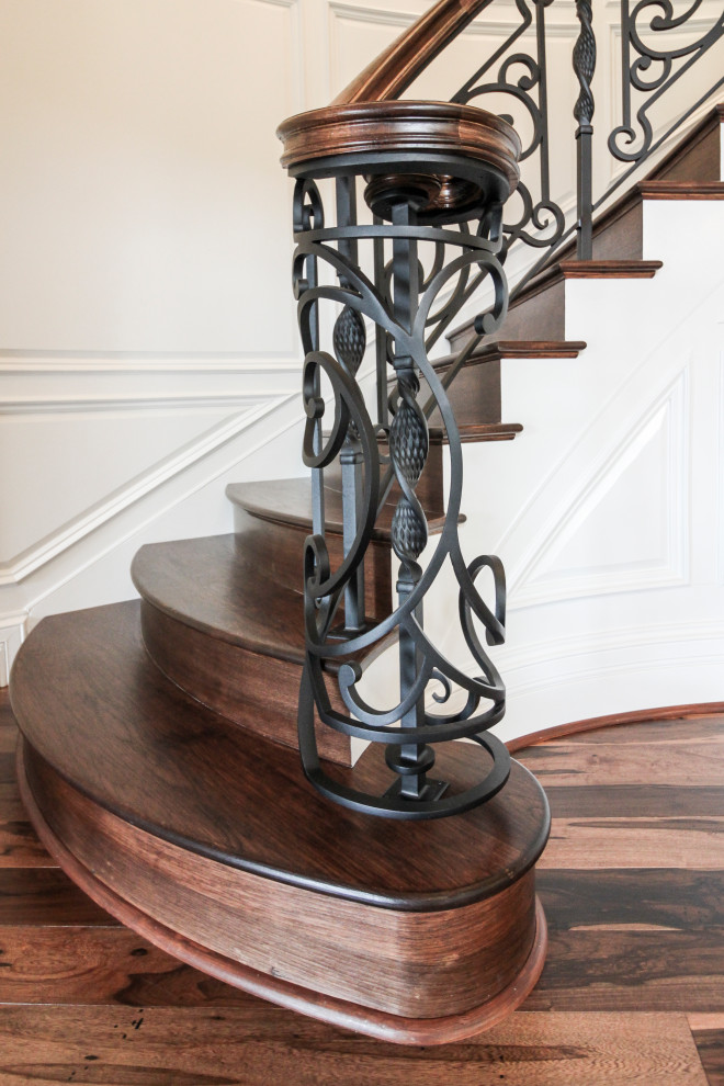 Cette image montre un grand escalier courbe bohème avec des marches en bois, des contremarches en bois et un garde-corps en matériaux mixtes.