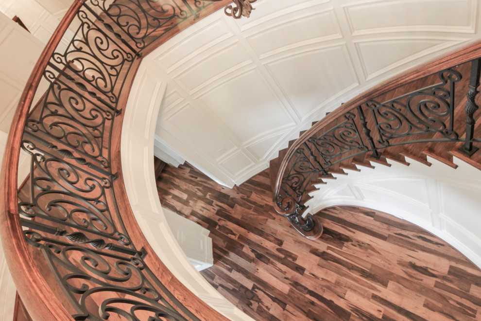 Ejemplo de escalera curva bohemia grande con escalones de madera, contrahuellas de madera y barandilla de varios materiales