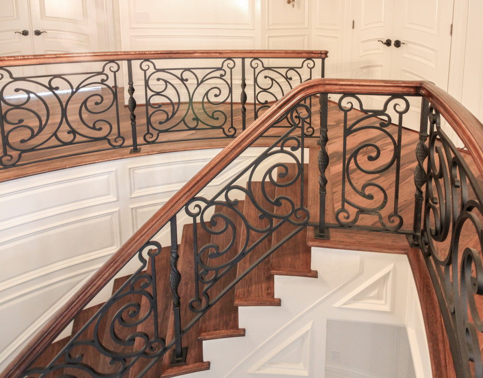 Cette image montre un grand escalier courbe bohème avec des marches en bois, des contremarches en bois et un garde-corps en matériaux mixtes.