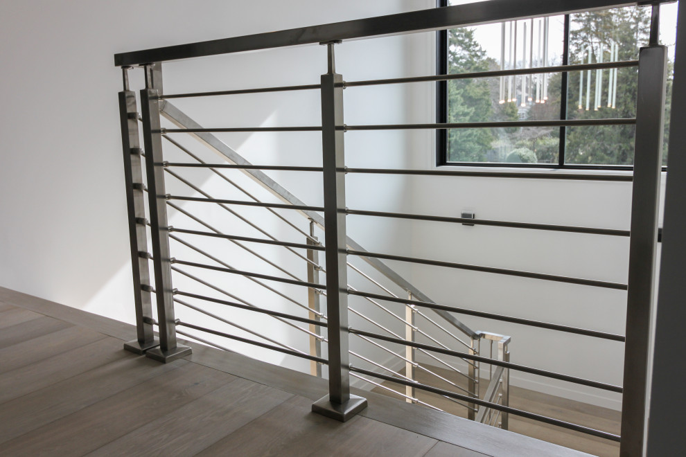 Foto de escalera en U minimalista de tamaño medio con escalones de madera, contrahuellas de madera y barandilla de metal