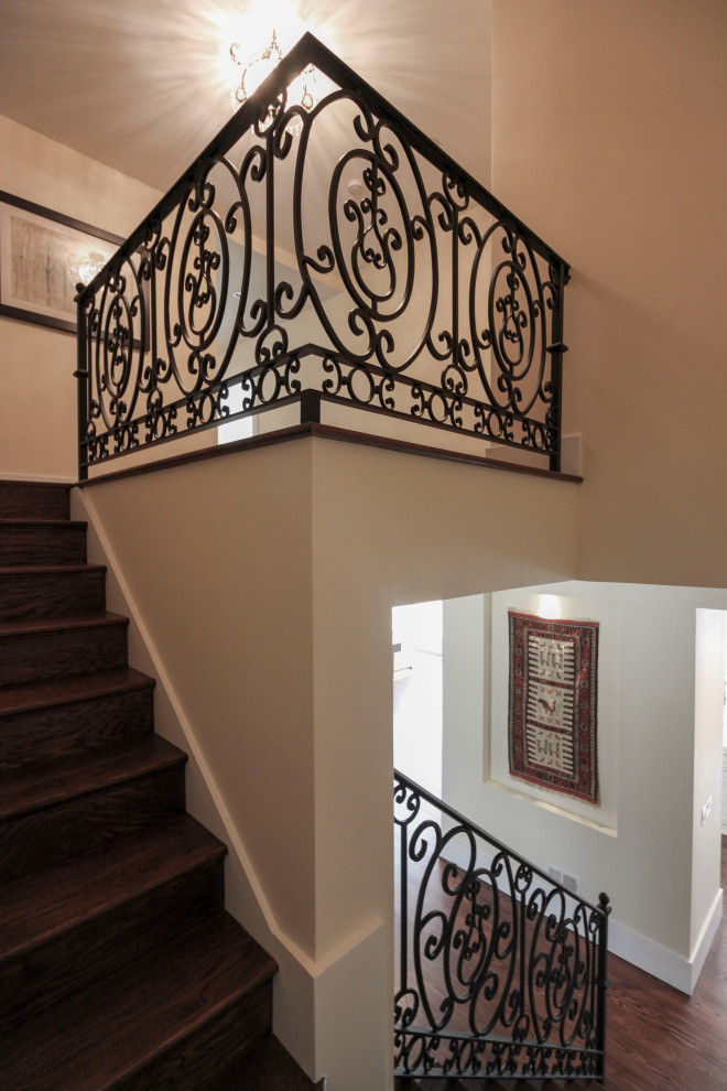Ejemplo de escalera curva tradicional renovada extra grande con escalones de madera, contrahuellas de madera y barandilla de metal