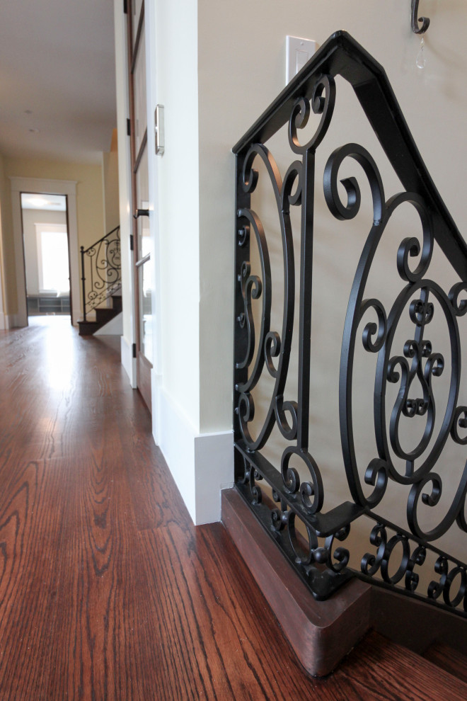 Inspiration for an expansive classic wood curved metal railing staircase in DC Metro with wood risers.