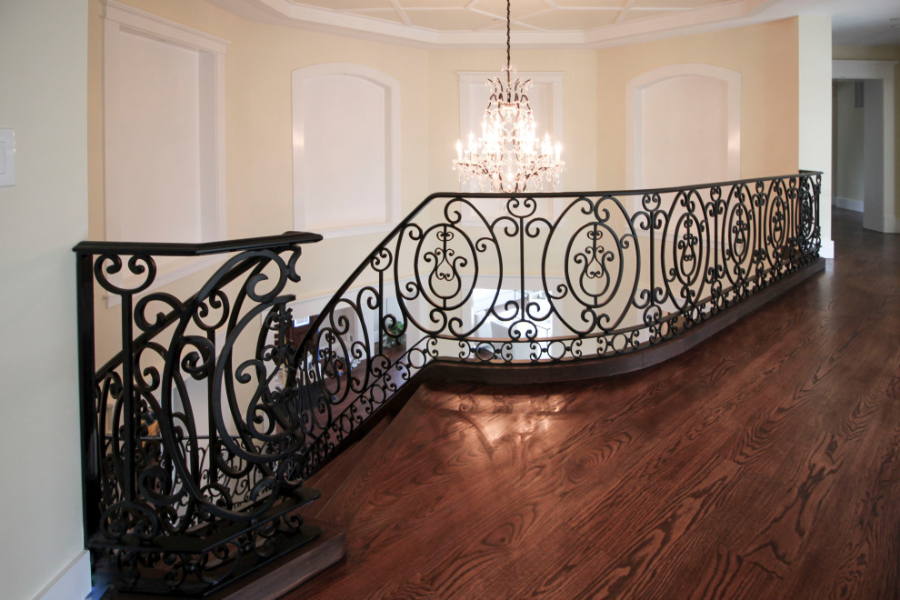 Ejemplo de escalera curva clásica renovada extra grande con escalones de madera, contrahuellas de madera y barandilla de metal