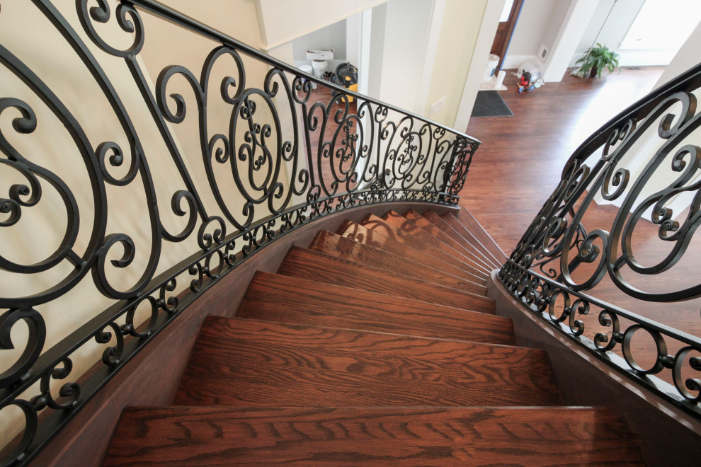 Design ideas for an expansive classic wood curved metal railing staircase in DC Metro with wood risers.