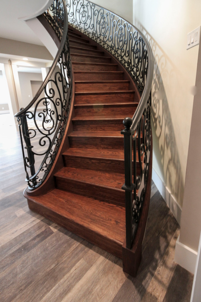 Staircase - huge transitional wooden curved metal railing staircase idea in DC Metro with wooden risers