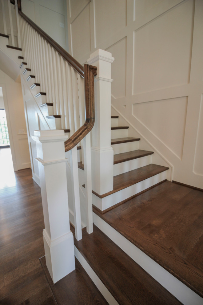 Imagen de escalera en U tradicional renovada grande con escalones de madera, contrahuellas de madera, barandilla de madera y boiserie